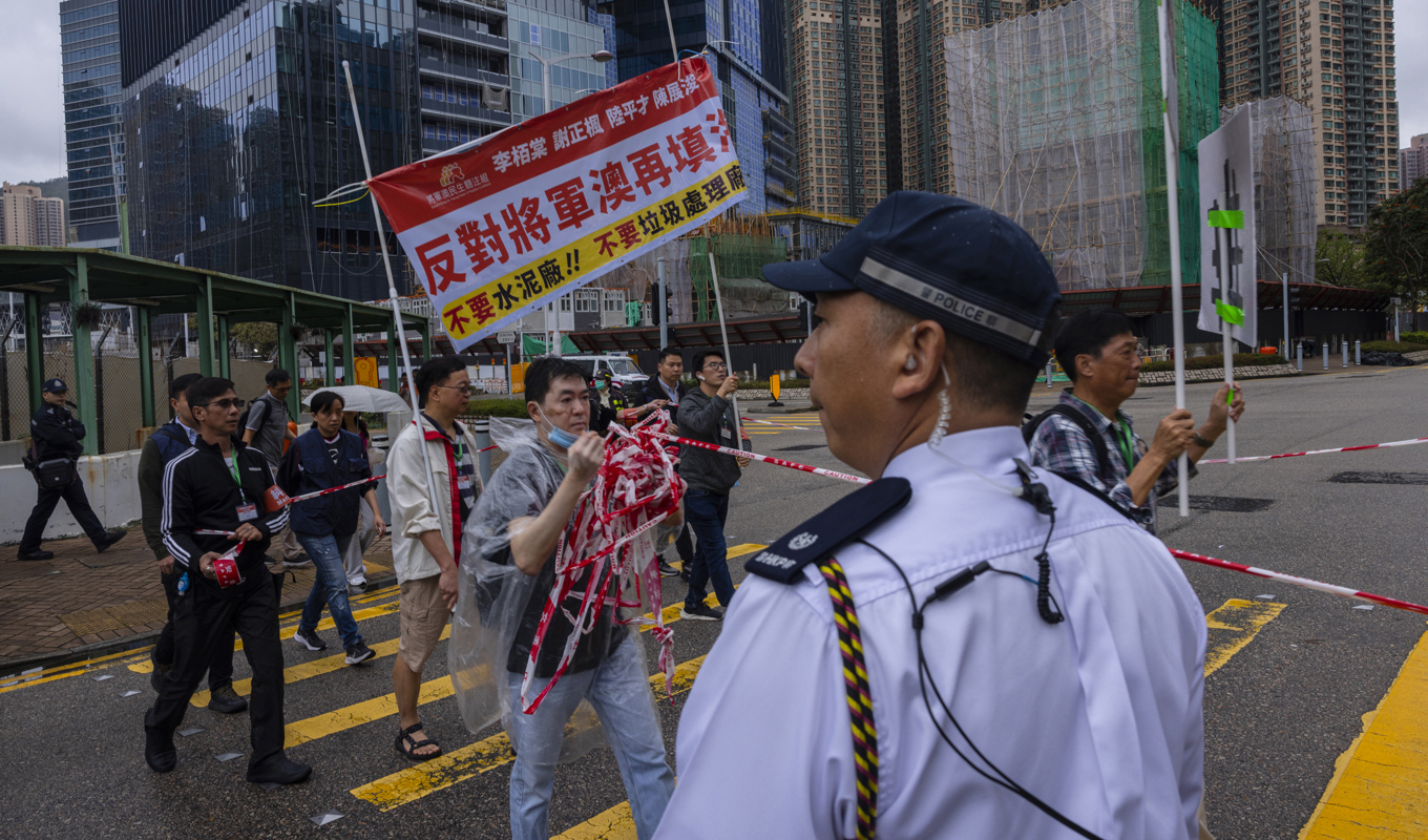 Polis följer en noggrant kontrollerad protest mot en sopstation i Tseung Kwan O i Hongkong. Foto: Louise Delmotte/AP/TT