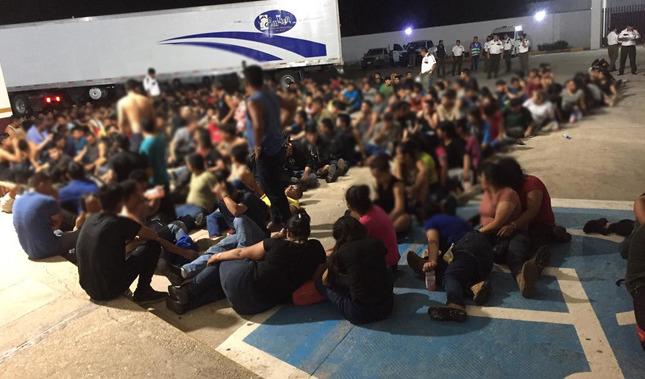 Migranter sitter i närheten av en lastbil i Mexiko. Foto: Det mexikanska nationella migrationsinstitutet (INM).