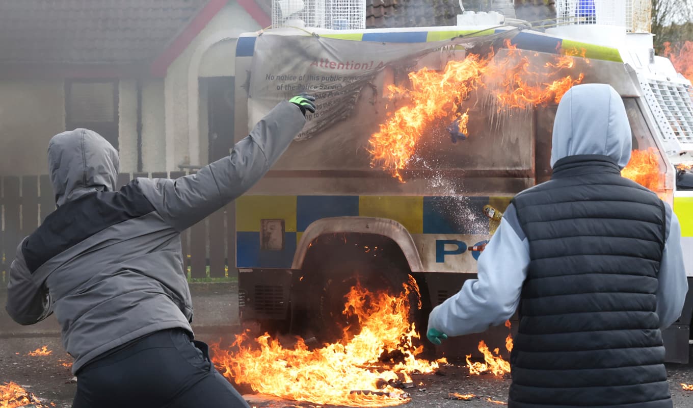 Maskerade ungdomar kastar bensinbomber mot polisfordon i Derry i Nordirland. Foto: Peter Morrison/AP/TT