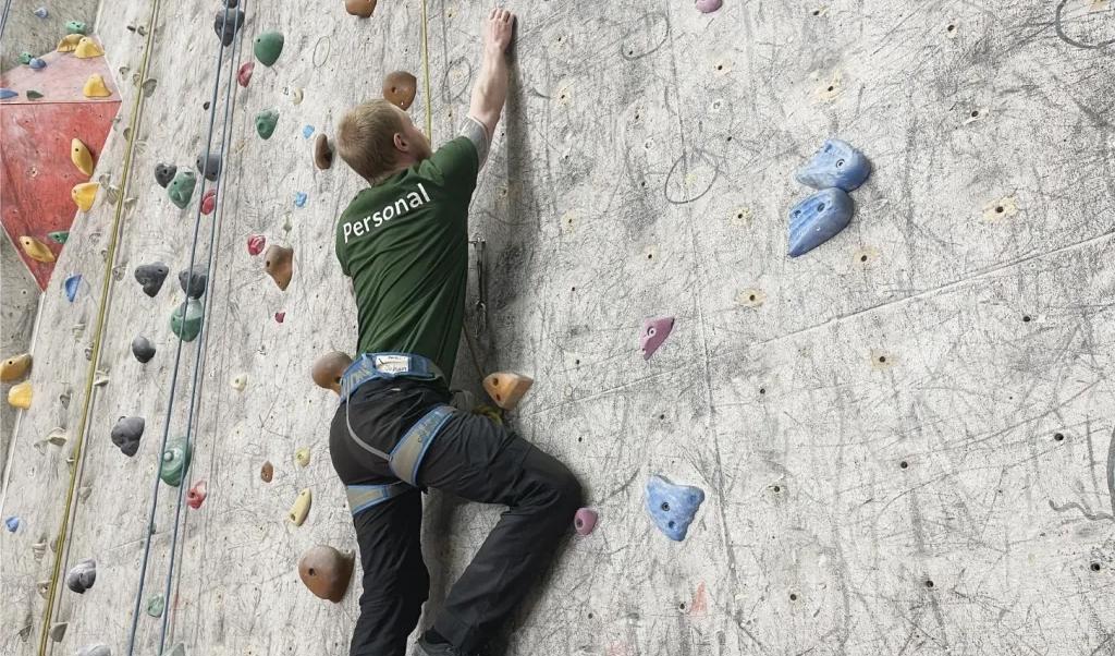 Johan Sjöstrand, platschef på Norrköpings klätterhall, klättrar till synes enkelt och obehindrat uppför väggen, fastspänd i ett rep.Foto: Göran Jacobson