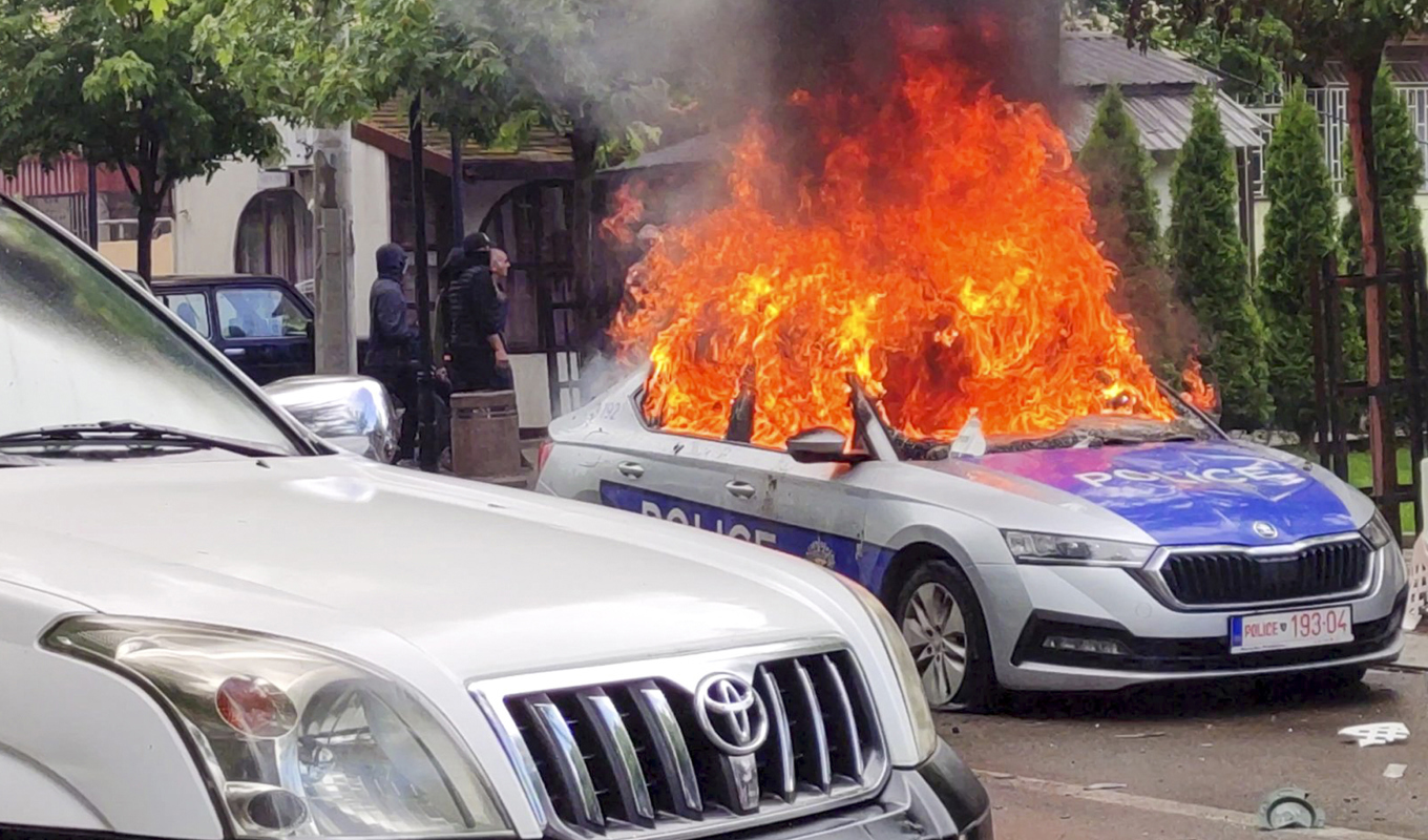 Polisbil i brand i samband med protester i staden Zvecan i norra Kosovo. Foto: AP/TT