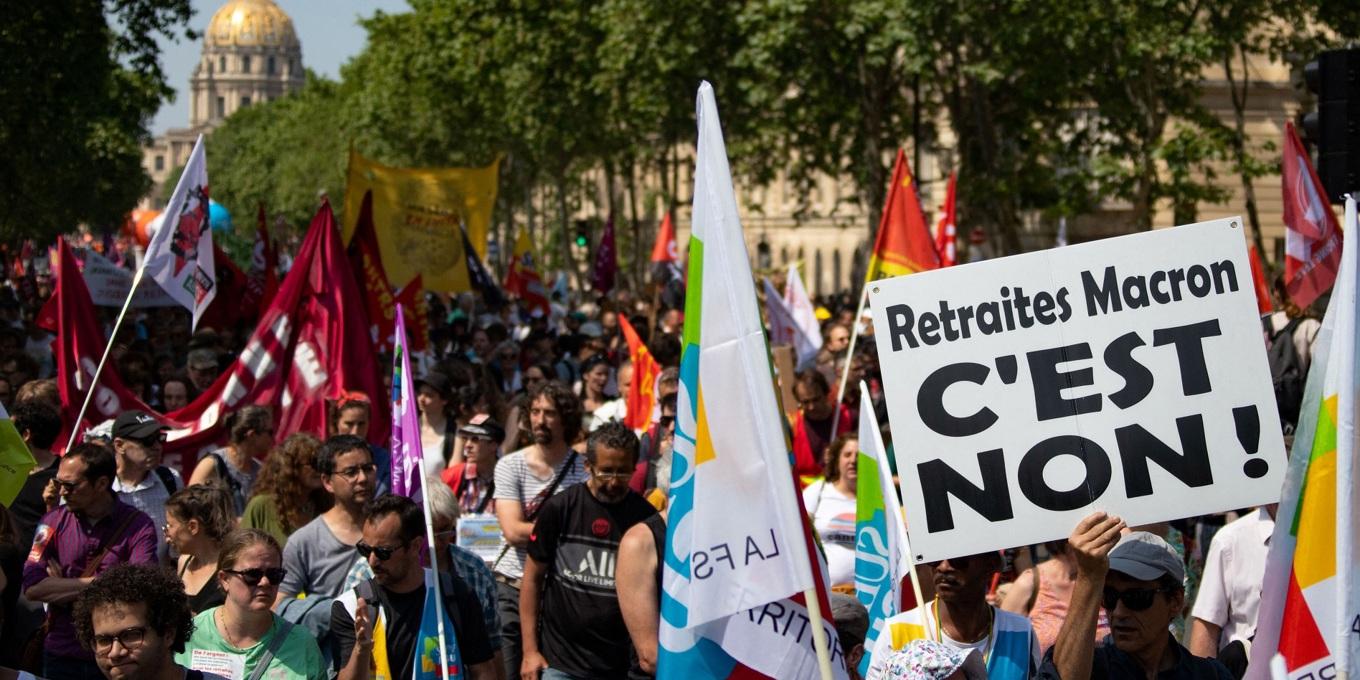 En demonstrant håller upp en skylt med texten ”Nej till Macrons pensioner” i samband med en demonstration i Frankrikes huvudstad Paris den 6 juni 2023. Foto: AFP via Getty Images