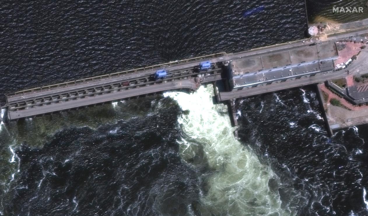Satellitbild över kraftverksdammen Kachovka där vatten forsar fram. Foto: Maxar Technologies/AP/TT