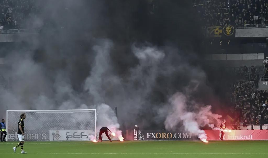 Maskerade AIK-supportrar kastade in brinnande bengaler på planen under det allsvenska derbyt mellan Djurgården och AIK på Tele 2 Arena.Foto: Jonas Ekströmer/TT