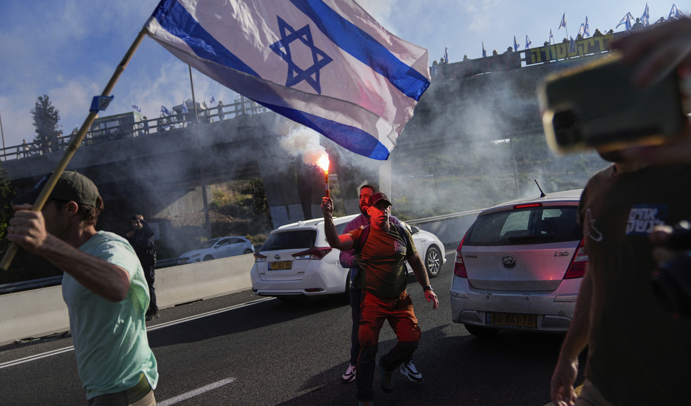 Demonstranter blockerar en motorväg som leder till Jerusalem, i protest mot regeringens planer på att kraftigt förändra det israeliska rättsväsendet. Foto: Ohad Zwigenberg/AP/TT