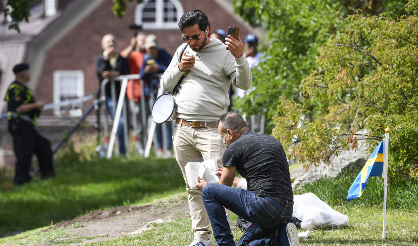 Manifestation utanför Iraks ambassad i Stockholm under torsdagen. Ett hörn av en sida i koranen har brännmärken. Foto: Oscar Olsson/TT
