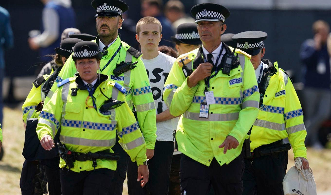 Aktivister leds bort av polis. Foto: David Davies/AP/TT