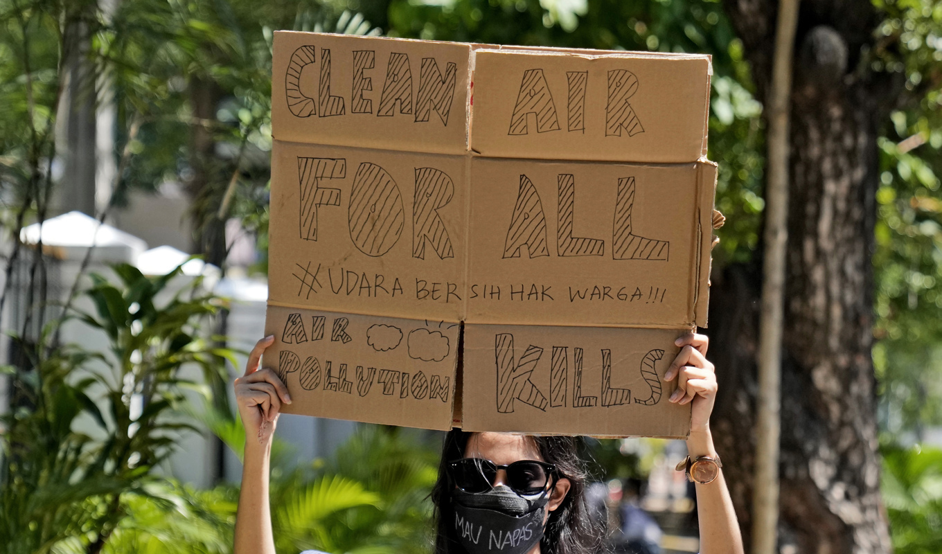 En domstol i Jakarta slog 2021 fast att presidenten och flera topptjänstemän har gjort för lite för att förbättra luften i huvudstaden. Här ses en aktivist utanför domstolen inför att den skulle meddela sitt beslut. Arkivbild. Foto: Dita Alangkara/AP/TT