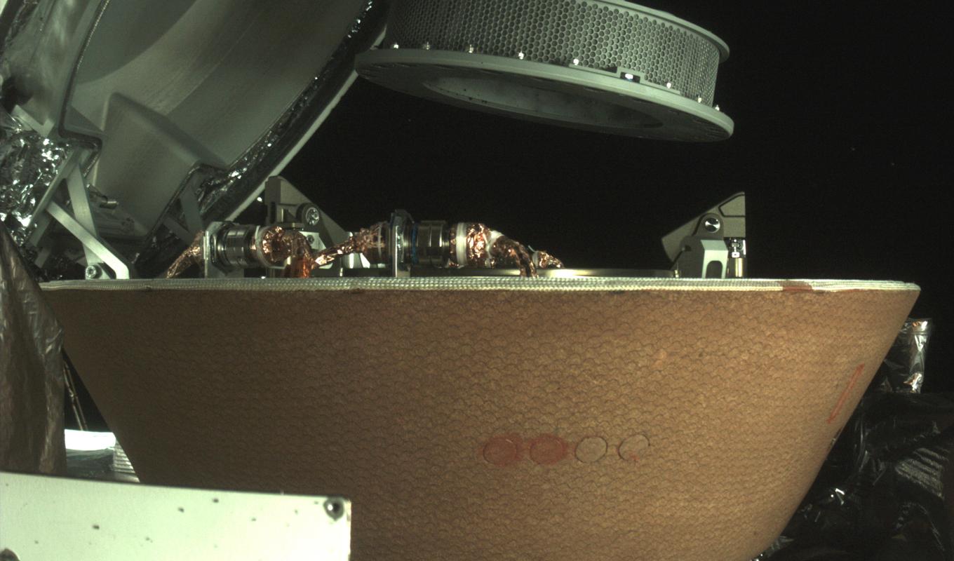 En bild från Nasa visar en provbehållare ovanför en kapsel på Osiris Rex-sonden nära asteroiden Bennu. Arkivbild. Foto: Nasa/AP/TT
