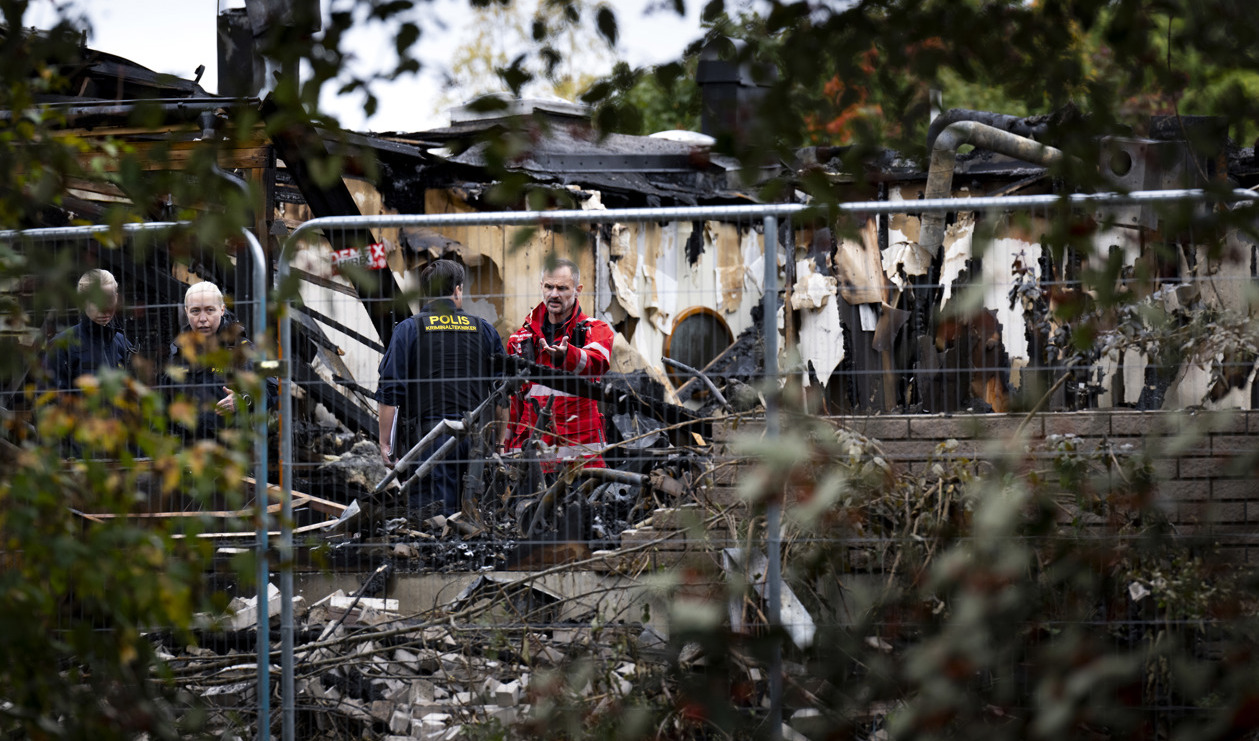 Polisens kriminaltekniker och personal från räddningstjänsten inspekterar det eldhärjade radhuset i radhusområdet i Hässelby dagen efter att ett av radhusen utsatts för ett sprängdåd med efterföljande brand. Foto: Pontus Lundahl/TT