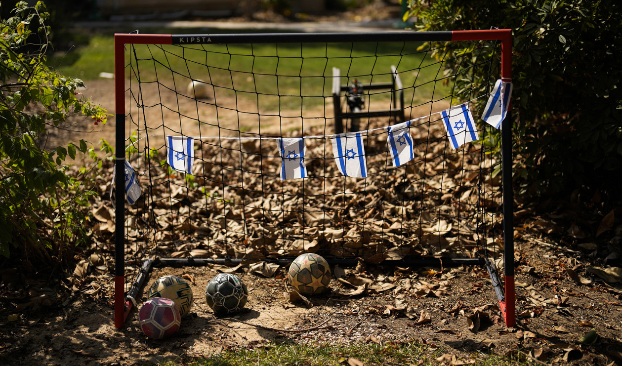 Israeliska flaggor vid ett fotbollsmål i en kibbutz som attackerades av Hamas den 7 oktober. Arkivbild. Foto: Francisco Seco/AP/TT