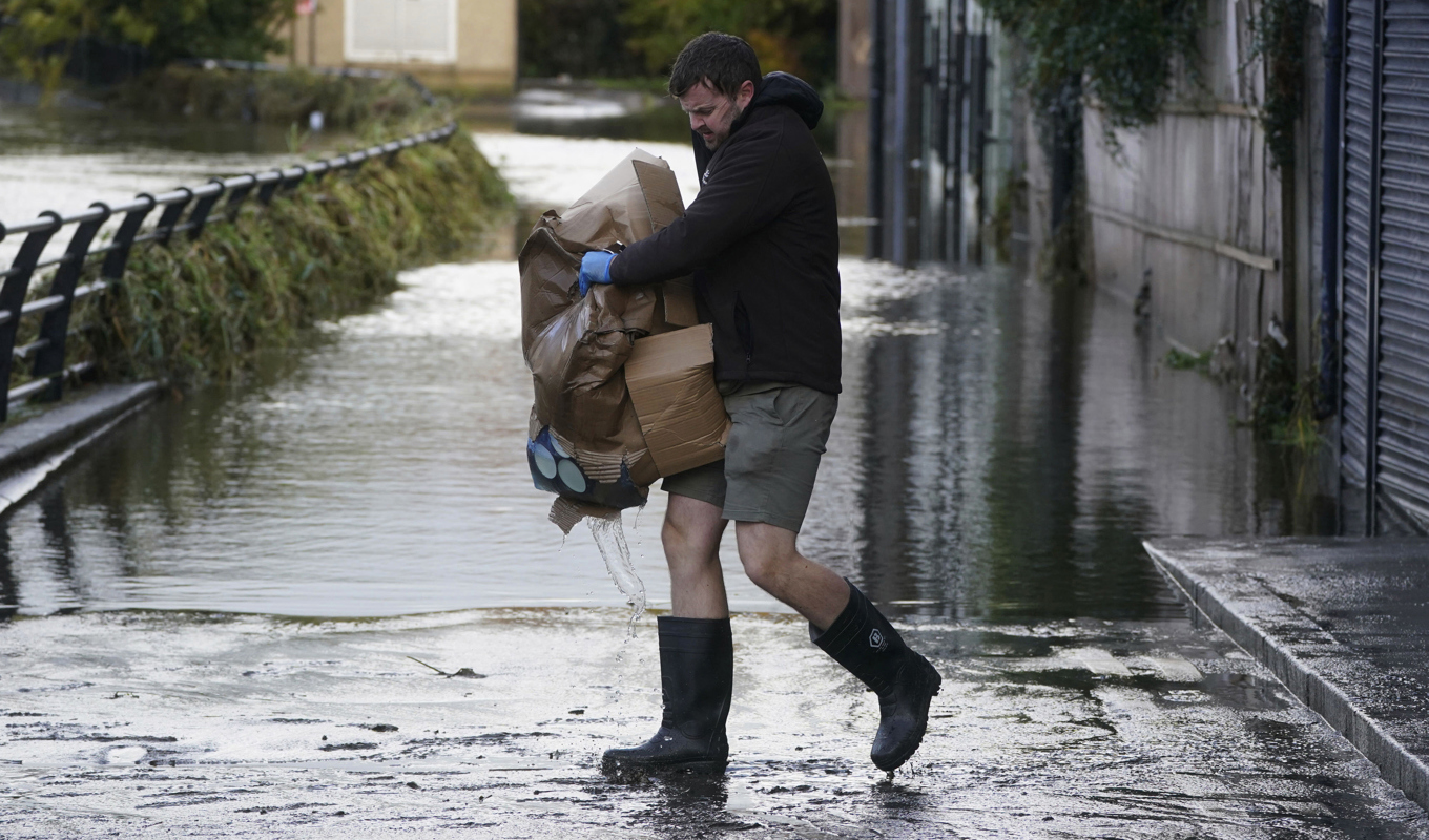 En man i Newry Town i Nordirland förbereder sig inför de regn som ovädret Ciarán tros föra med sig. Foto: Brian Lawless/AP/TT