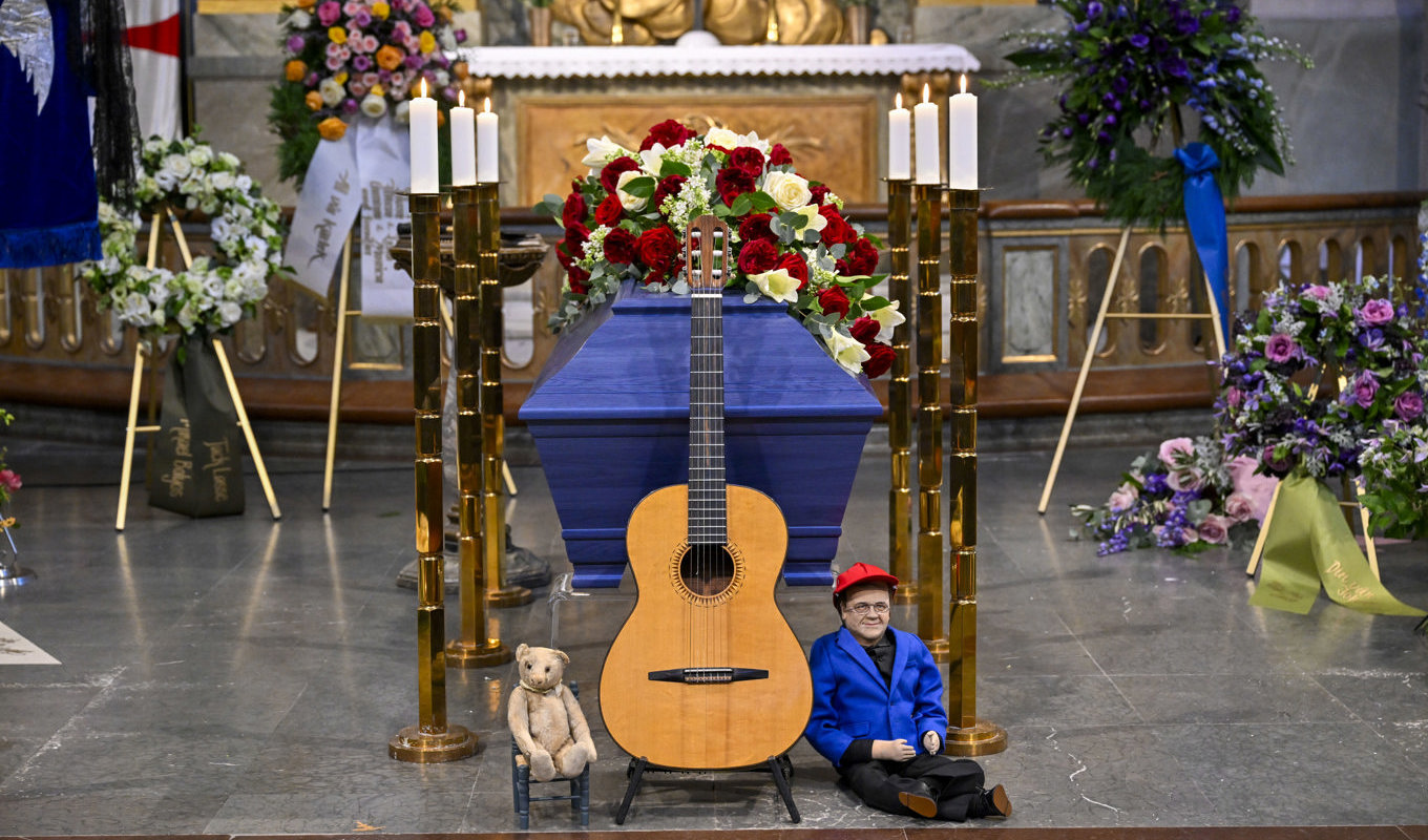 Vid kistan var både Lasse Berghagens gitarr och den omsjungna teddybjörnen placerade. Foto: Henrik Montgomery/TT