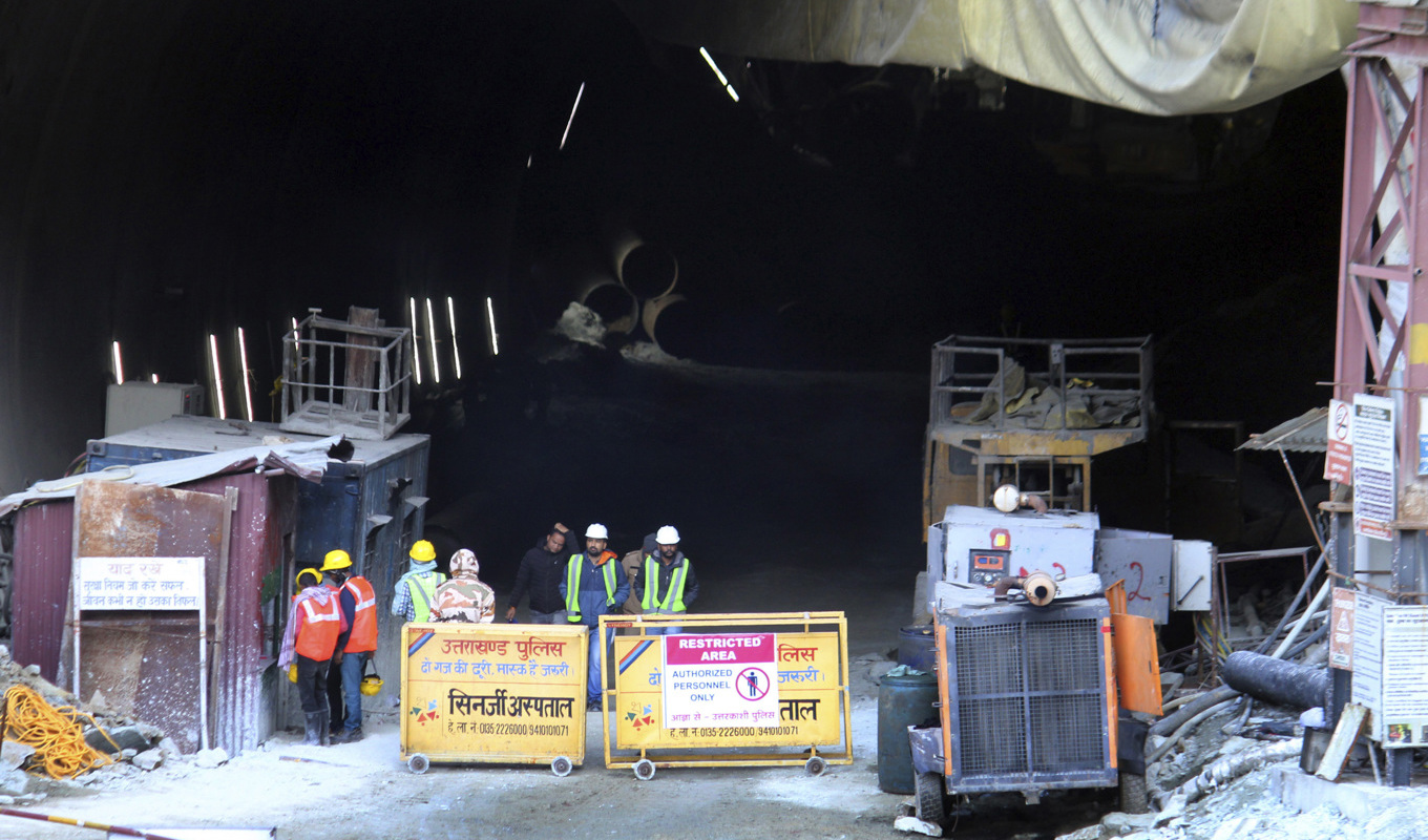 Räddningspersonal och säkerhetspersonal vid ingången till tunneln som rasade den 12 november. Bilden togs i fredags. Foto: AP/TT