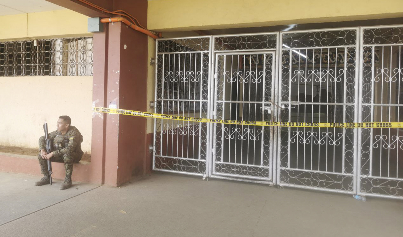 En filippinsk soldat vaktar ingången till lokalen i Marawi där bombattentatet skedde. Foto: Froilan Gallardo/AP/TT