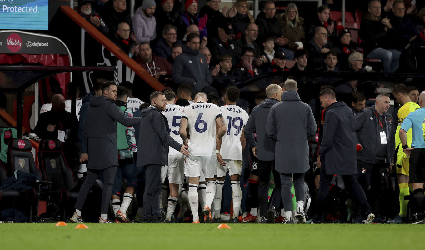 Lutons spelare lämnar planen sedan deras lagkapten Tom Lockyer kollapsat på planen i matchen mot Bournemouth. Foto: Steven Paston/AP/TT