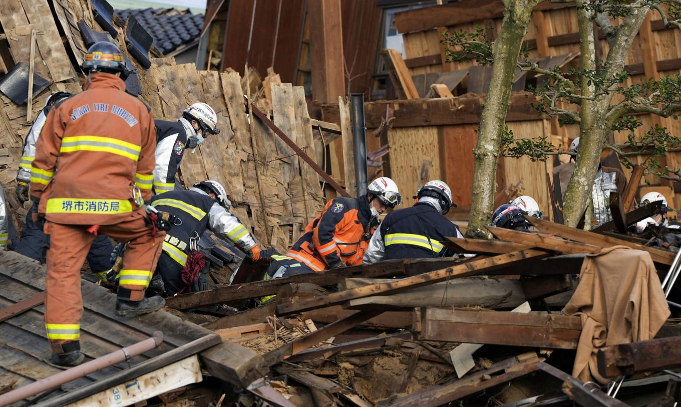 Räddningsarbetare söker efter överlevande i hamnstaden Wajima i Ishikawa-regionen. Foto: Kyodo News via AP/TT