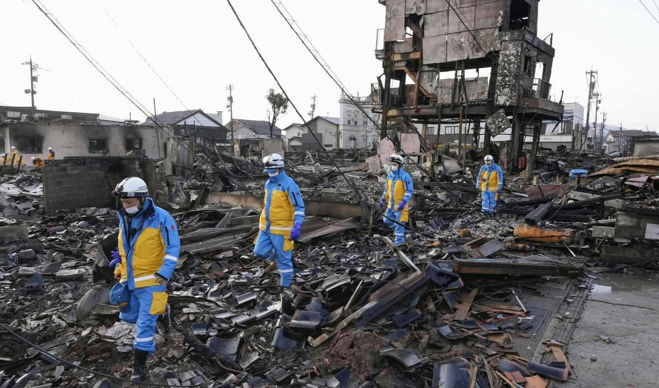 Polis söker i ruinerna av en nedbränd marknad i Wajima på västkusten i centrala Japan under lördagen. Foto: Kyodo News via AP/TT