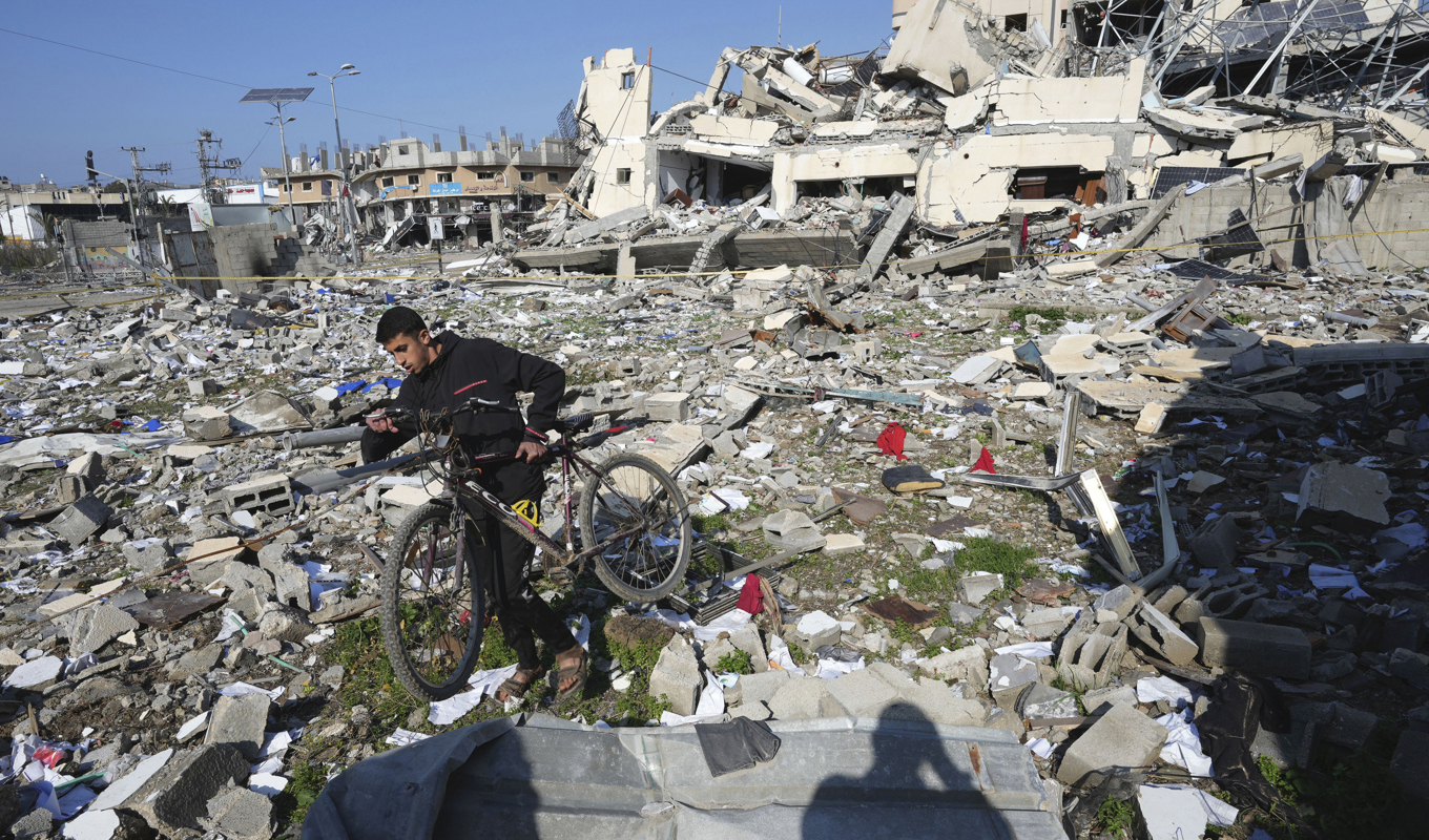 En man försöker ta sig igenom ett förstört kvarter i Gaza på tisdagen. Foto: Adel Hana/AP/TT