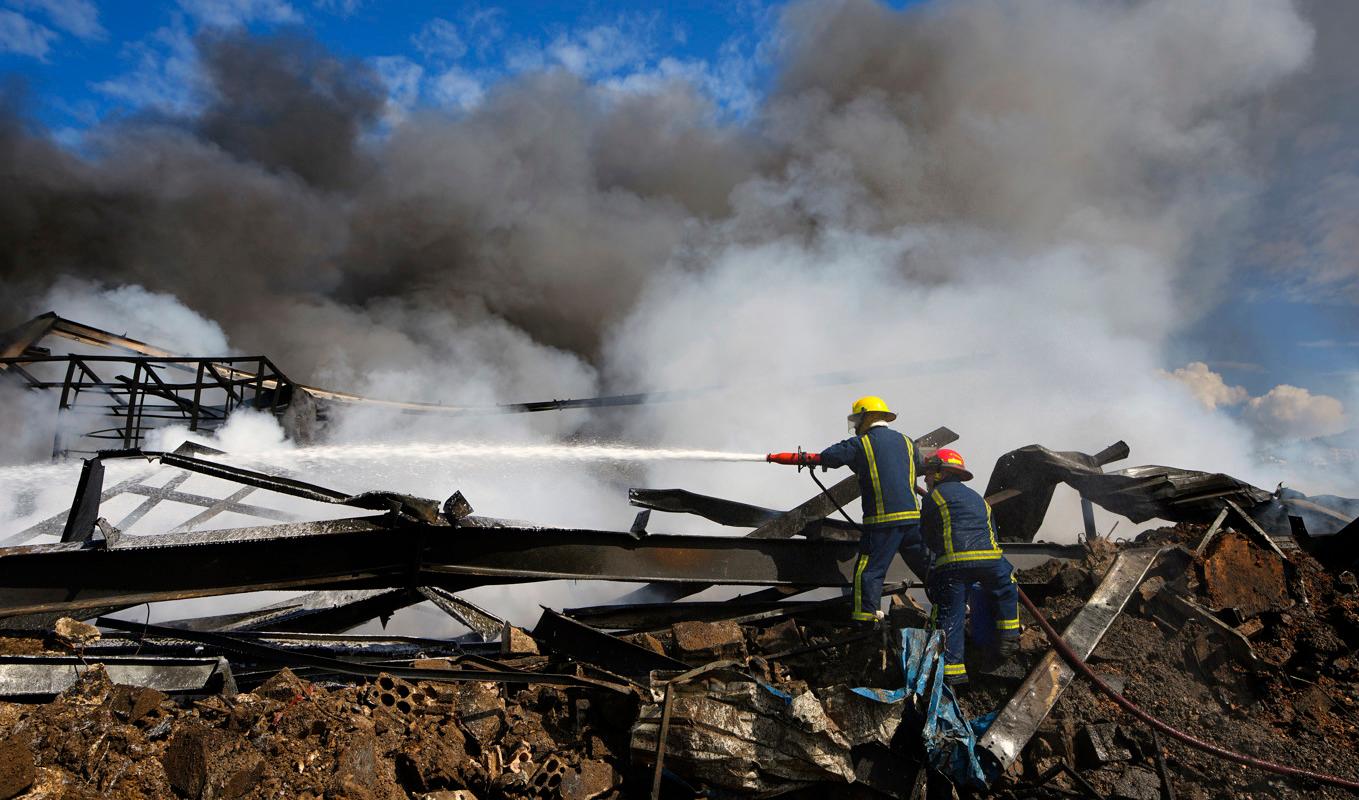 Räddningspersonal släcker en brand efter en israelisk flygräd mot mål i Libanon på tisdagen. Foto: Bilal Hussein/AP/TT