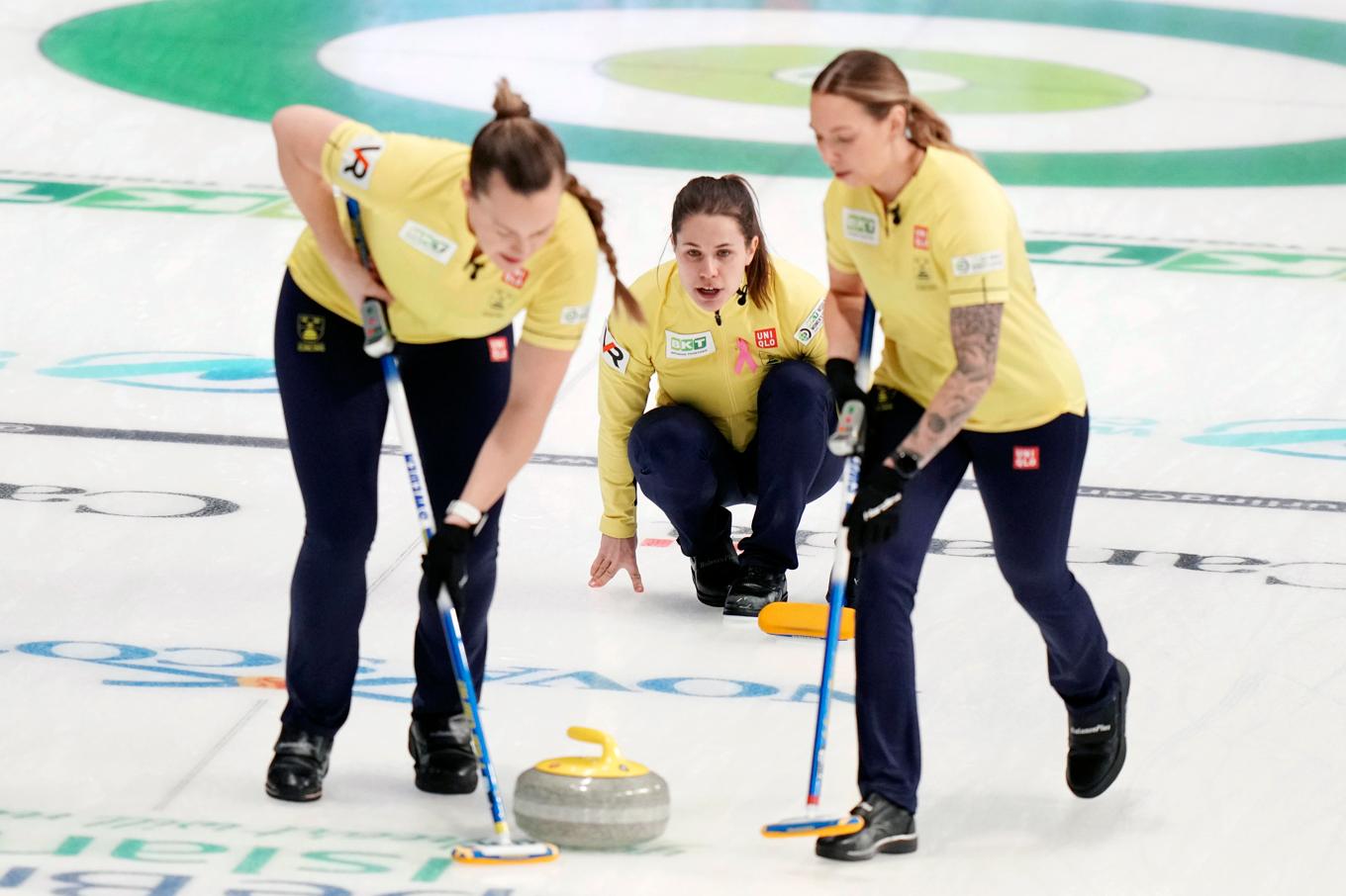 Svenska skippern Anna Hasselborg (i mitten) och Agnes Knochenhauer (till vänster) och Sofia Mabergs (till höger) under matchen mot USA. Sedan blev det förlust mot Sydkorea men slutspelshoppet lever i curling-vm för damer i Kanada, för Sverige. Foto: Darren Calabrese/AP/TT