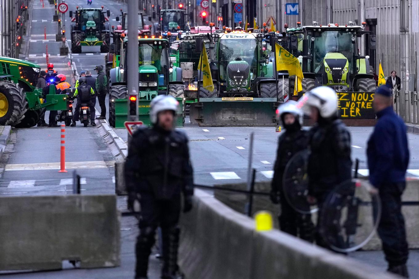 Traktorer mot kravallpolis i EU-kvarteren i Bryssel inför tisdagens jordbruksministermöte. Foto: Virginia Mayo/AP/TT