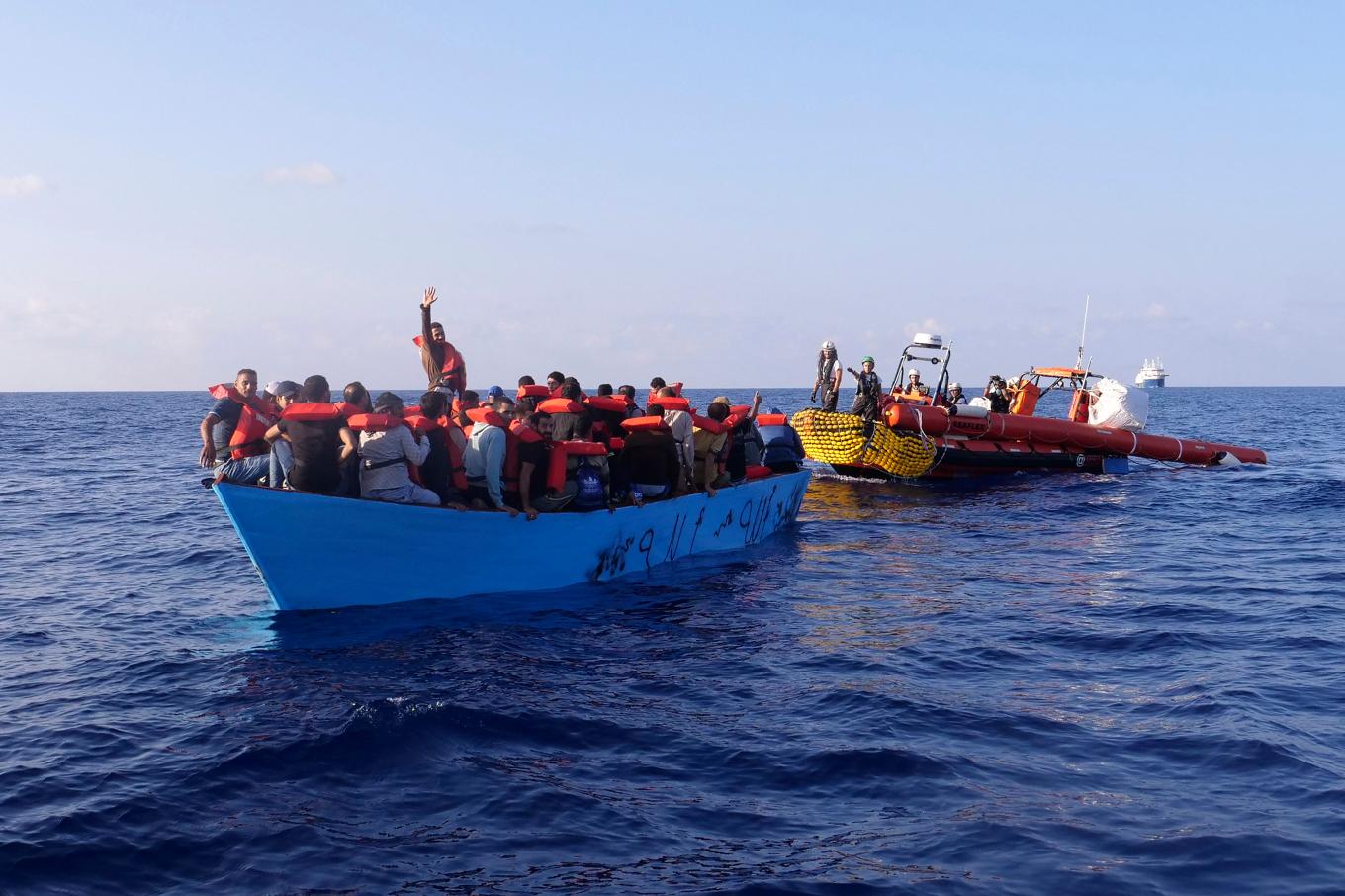 Migranter möts upp av en båt från Läkare utan gränser utanför Libyen, i oktober förra året. Arkivbild. Foto: Paolo Santalucia/AP/TT