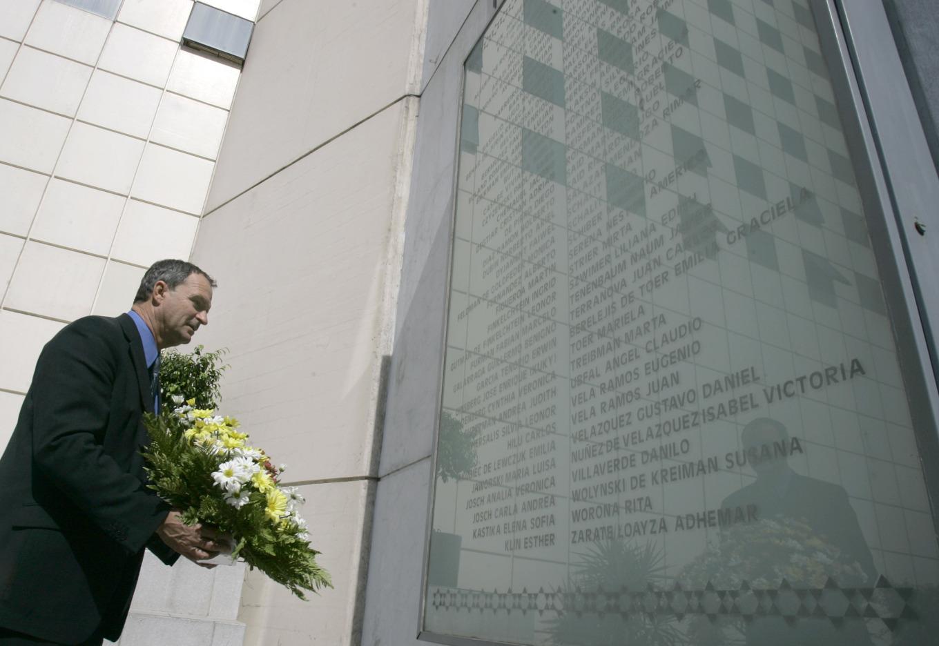 En judisk politiker håller en blombukett vid minnesmärket i Buenos Aires för attentatet mot en judisk inrättning där 85 människor dödades 1994. Arkivbild. Foto: NATACHA PISARENKO/AP/TT
