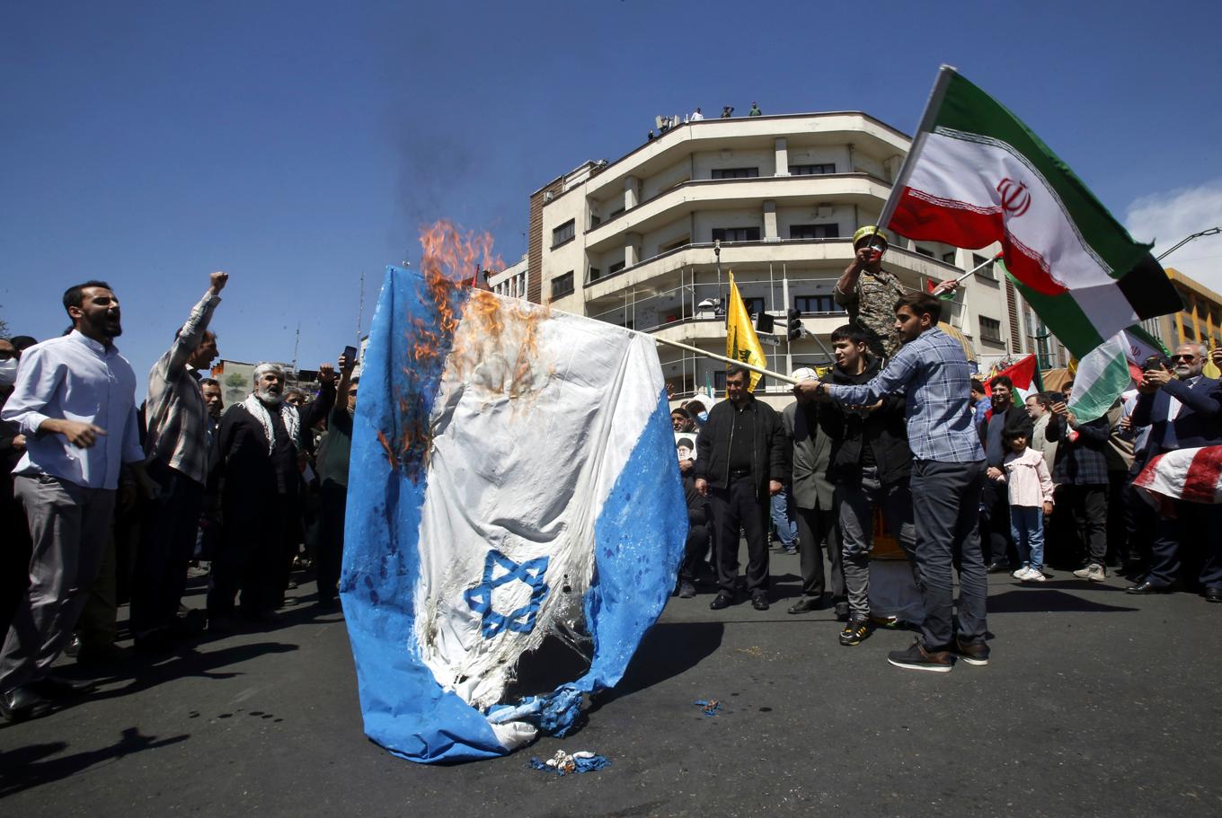 Iranska demonstranter bränner en israelisk flagga i samband med en begravningsprocession för de revolutionsgardister som dödades i Damaskus i förra veckan. Bild från Teheran den 5 april. Foto: Vahid Salemi/AP/TT