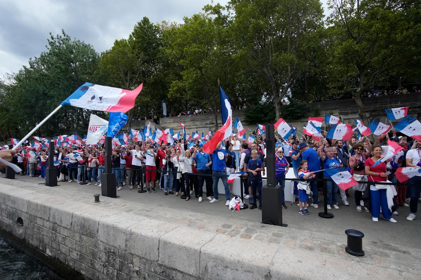 Franska supportrar längs floden Seine i samband med att den olympiska facklan visades upp i Paris förra sommaren. Arkivbild. Foto: Christophe Ena/AP/TT