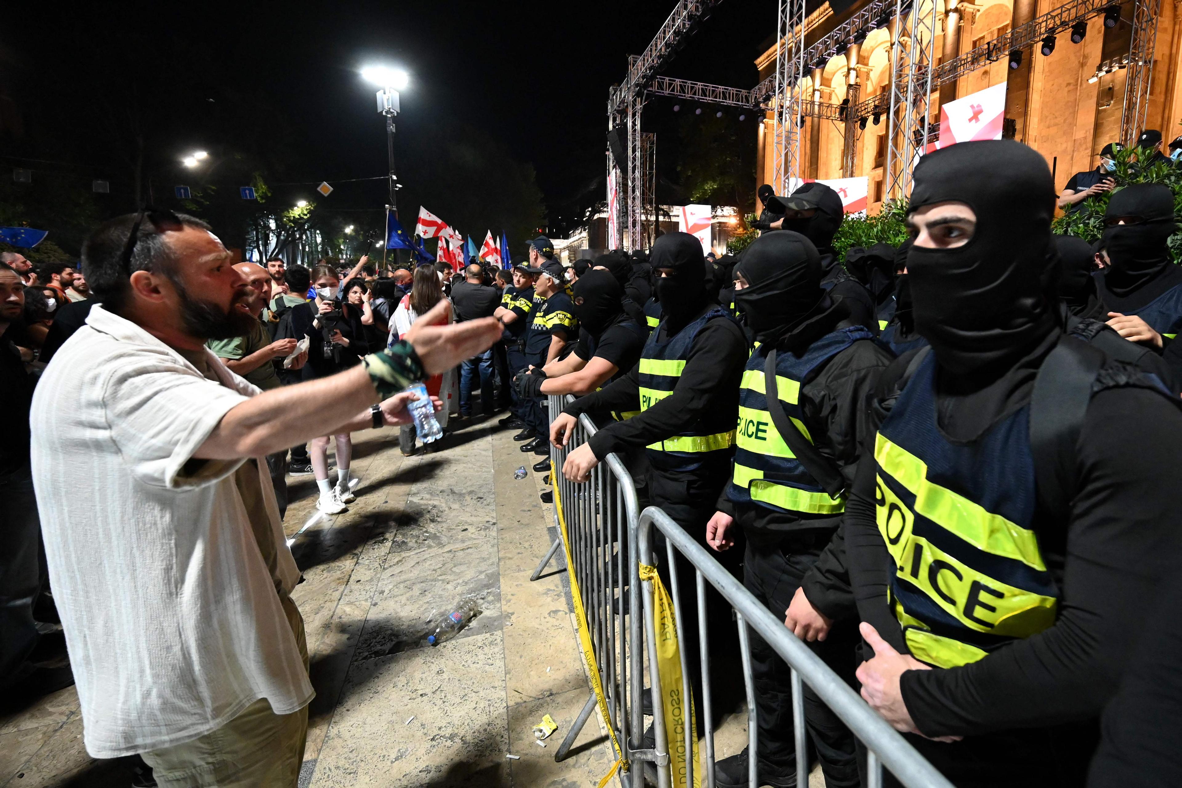 En man argumenterar med polis vid demonstrationerna i Tbilisi på söndagskvällen. Foto: Vano Shlamov/AFP/TT