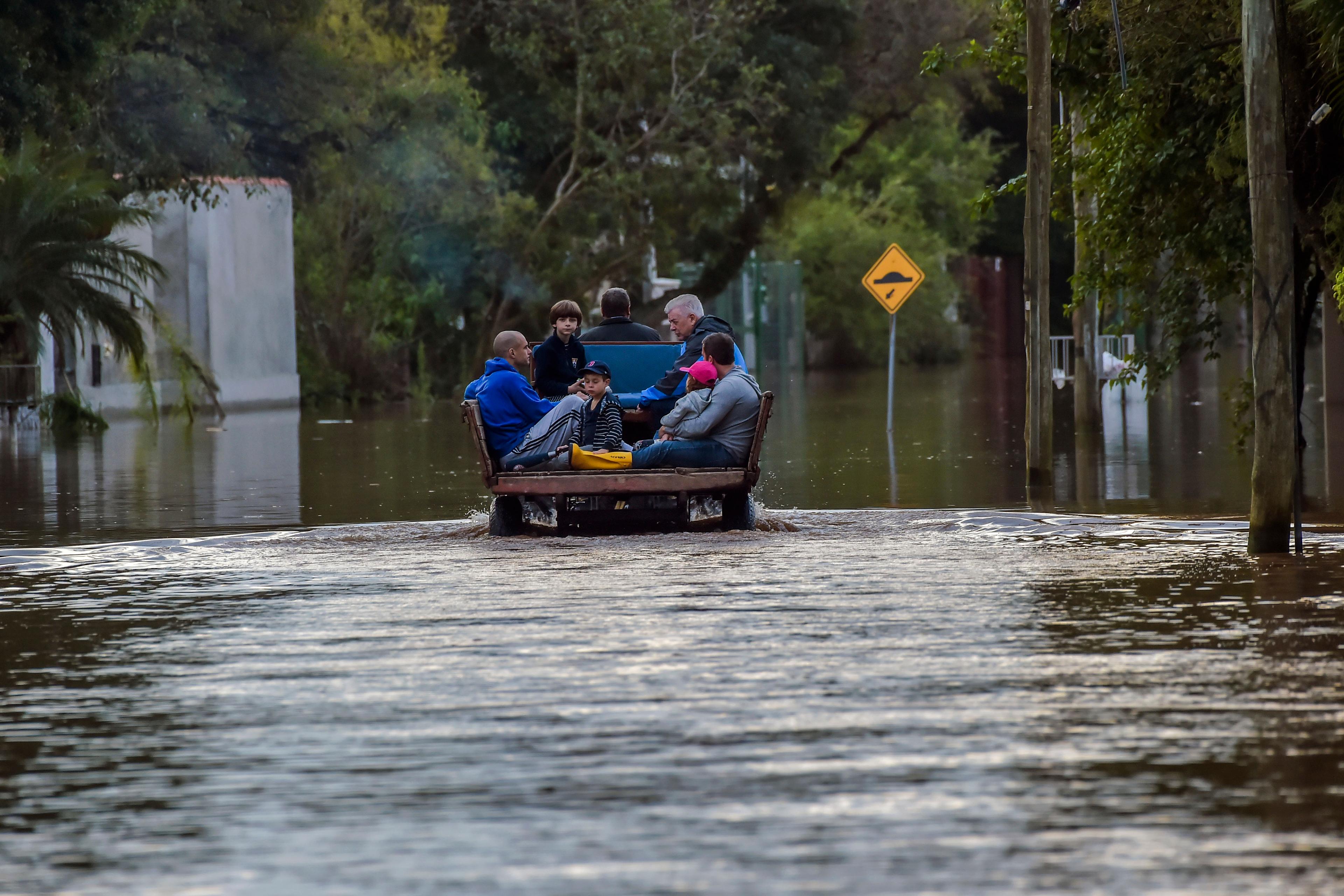 En familj evakueras vid en tidigare översvämning, förra året, i den brasilianska delstaten Rio Grande do Sul. Foto: Wesley Santos/AP/TT