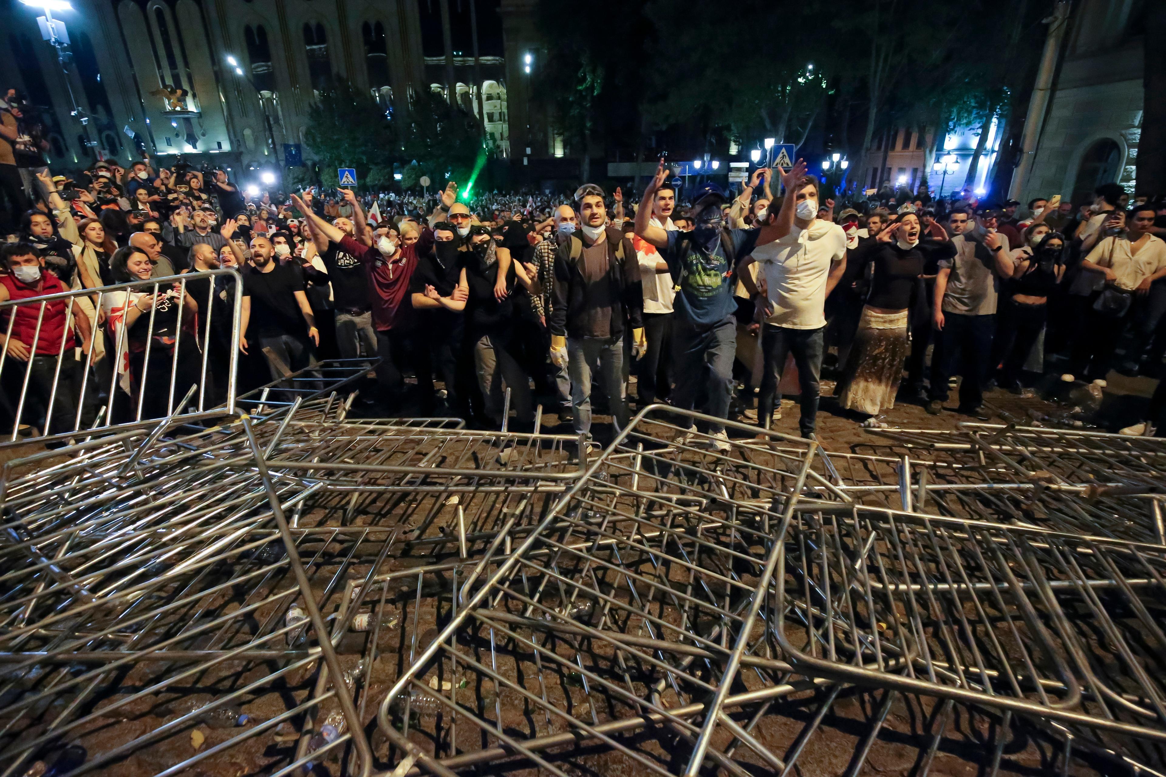 Demonstranter argumenterar med polis på plats vid parlamentsbyggnaden i centrala Tbilisi på tisdagskvällen. Foto: Zurab Tsertsvadze/AP/TT