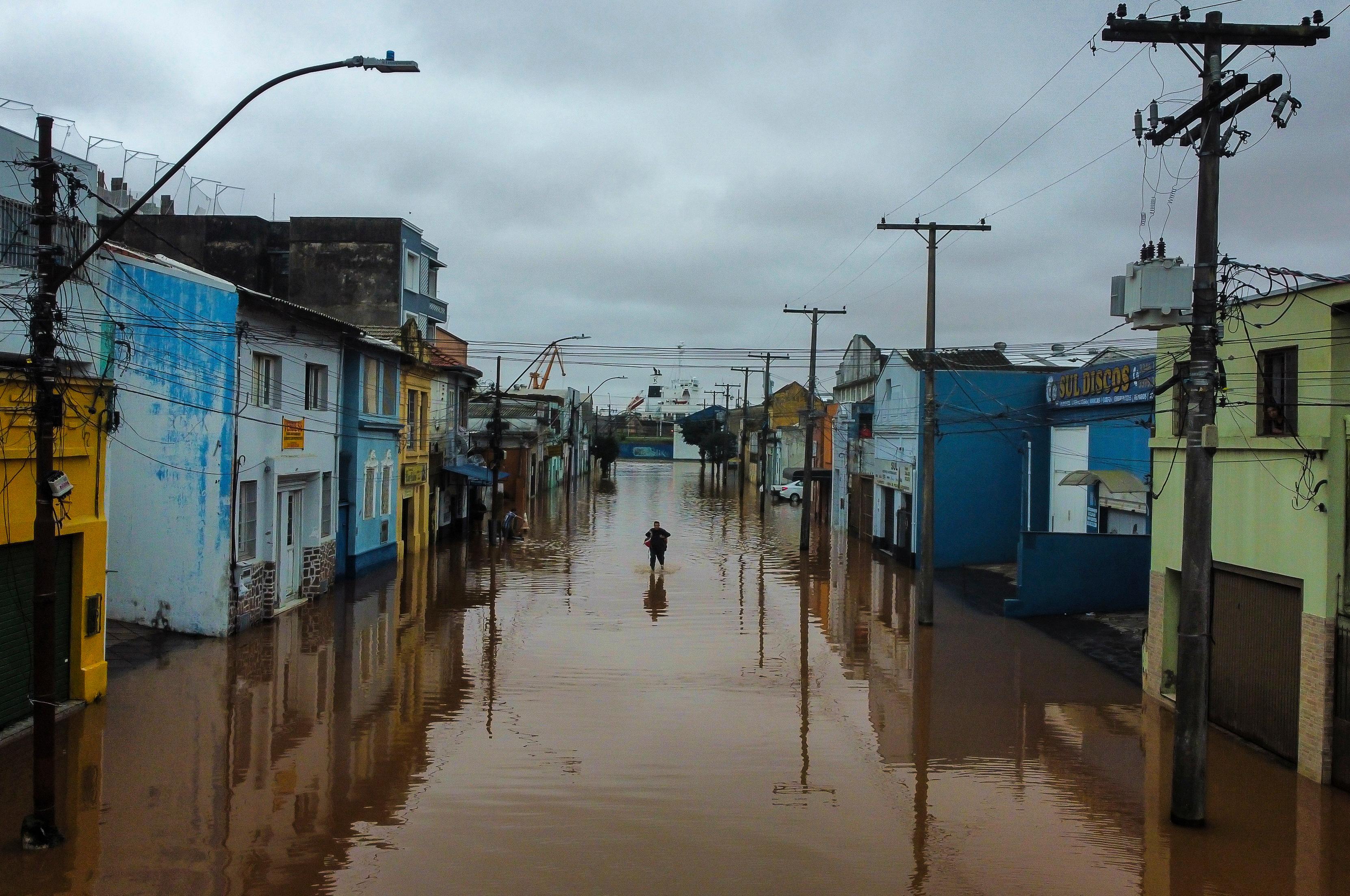 En man vadar fram i översvämningarnas Porto Alegre. Foto: Carlos Macedo/AP/TT