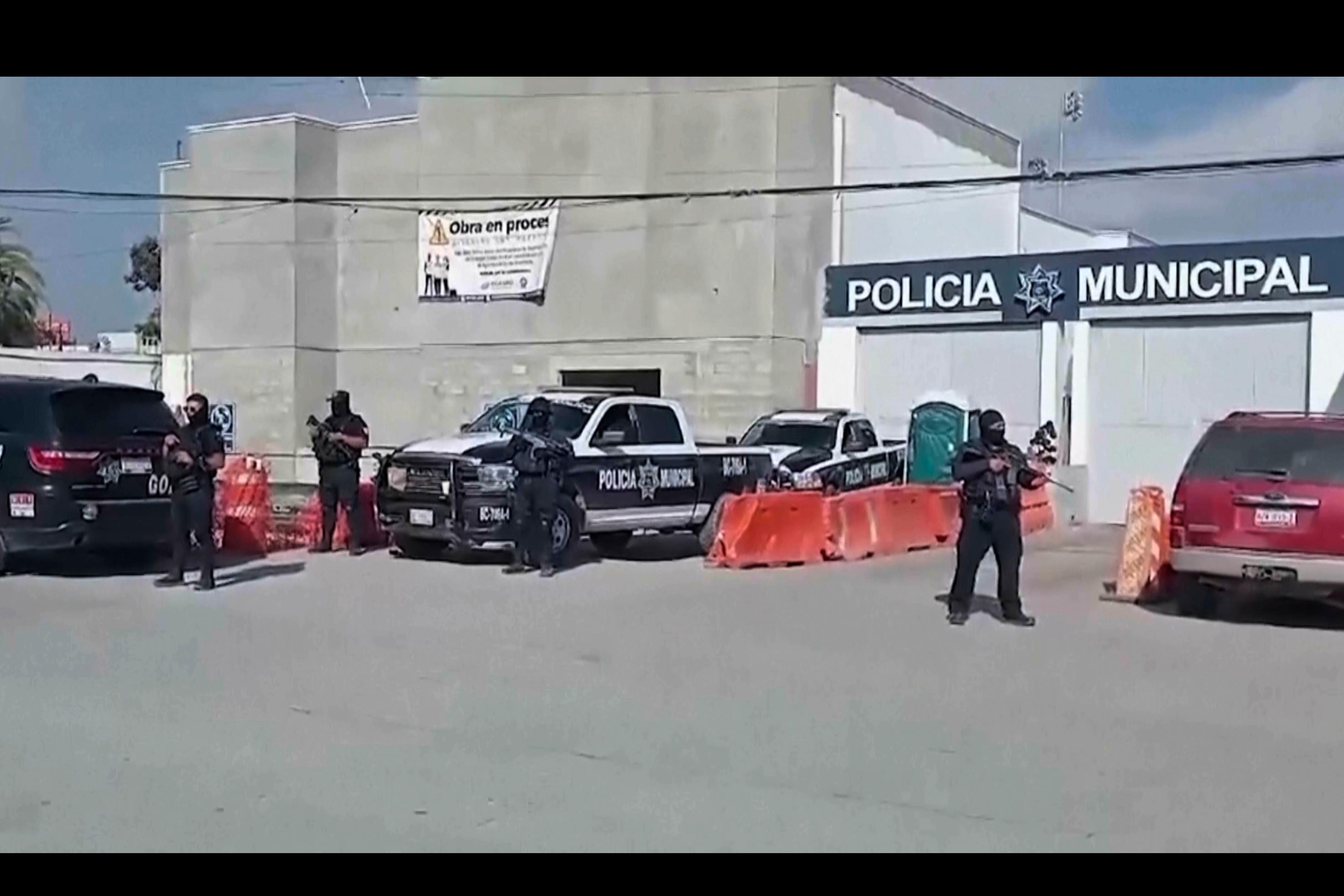 Mexikansk polis vaktar utanför polisstationen i Ensenada där tre personer förhörs i fallet med de saknade turisterna. Foto: TT/AP