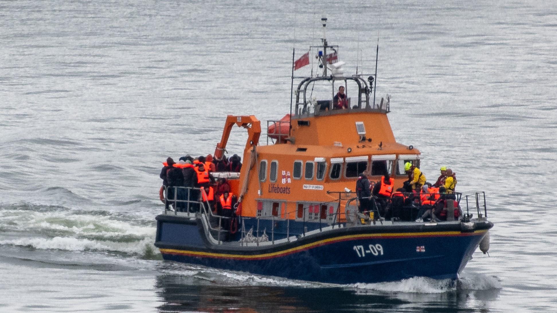 Migranter förs till Dovers hamn av en livräddningsbåt efter att ha plockats upp i Engelska kanalen när de försökte ta sig från Frankrike i uppblåsbara båtar den 23 april. Foto: Chris J Ratcliffe/Getty Images