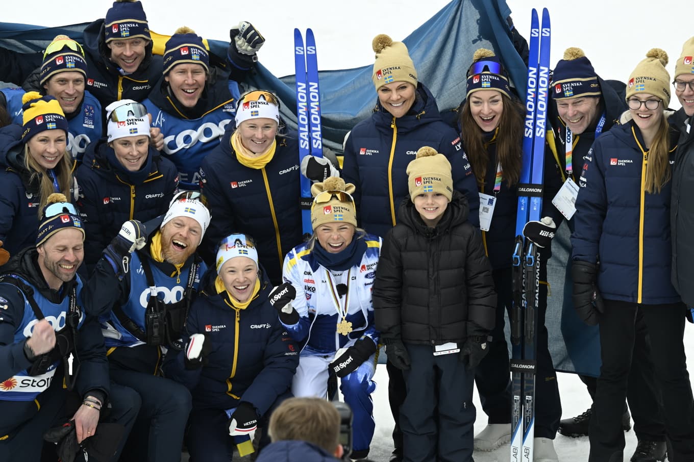 Kronprinsessan Victoria, prins Daniel, prinsessan Estelle och prins Oscar poserar för en gruppbild med det svenska längdlandslaget – bland andra Frida Karlsson, Jonna Sundling och landslagschef Anders Byström – efter söndagens avslutande femmil på skid-VM i Trondheim. Foto: Fredrik Sandberg/TT