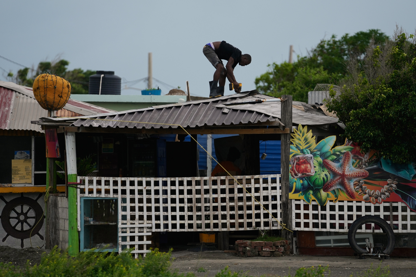 En man i huvudstaden Kingston förstärker ett tak under söndagen inför orkanen Melissa som drar in över Jamaica. Foto: Matias Delacroix/AP/TT