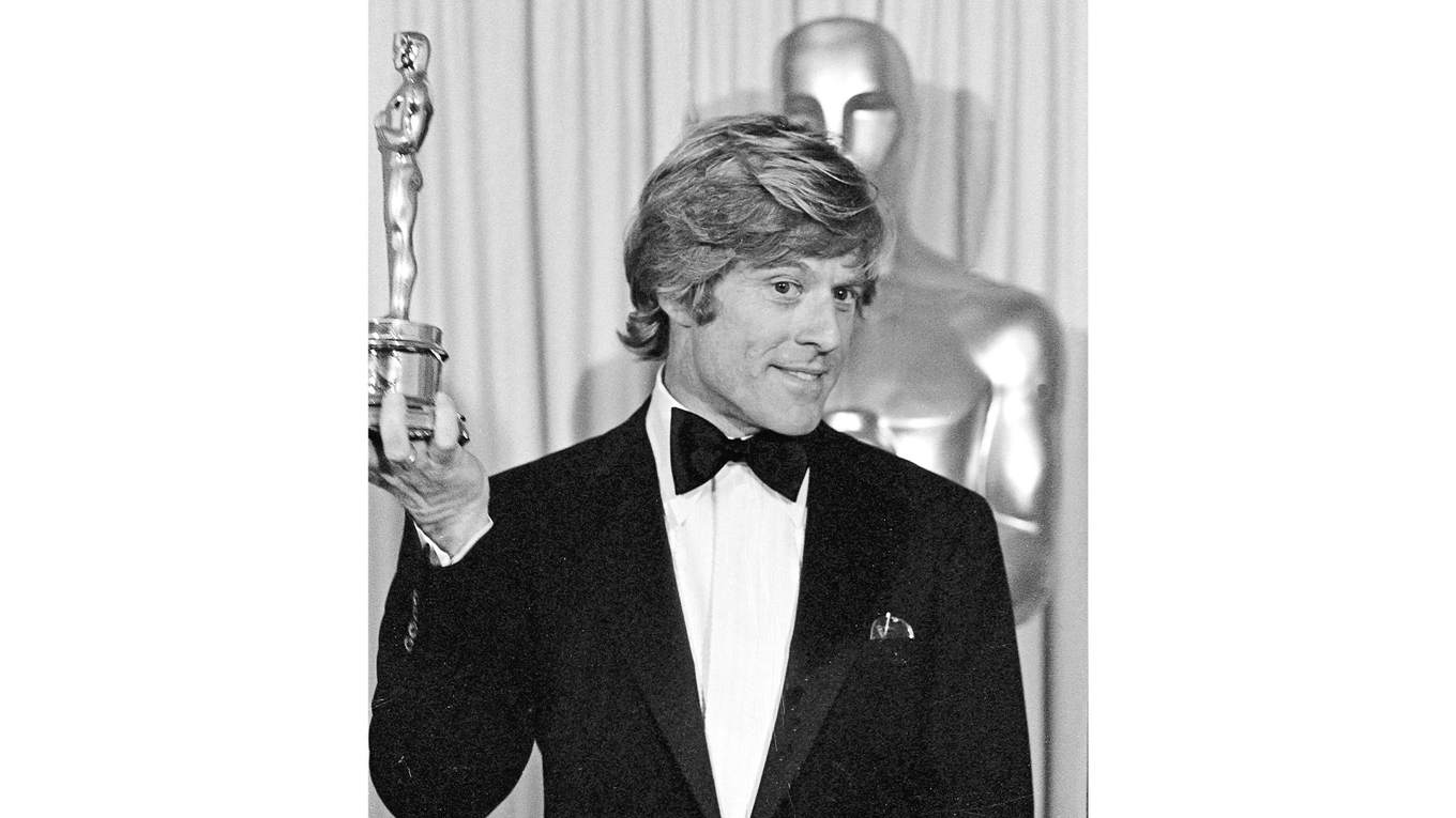 Den 31 mars 1981 håller Robert Redford upp den Oscar som han precis har tilldelats för bästa regi för filmen ”En familj som andra”. Han lär vid något tillfälle ha sagt: ”Som regissör skulle jag inte tycka om mig själv som skådespelare. Som skådespelare skulle jag inte tycka om mig själv som regissör.” Foto: AP/TT BILD