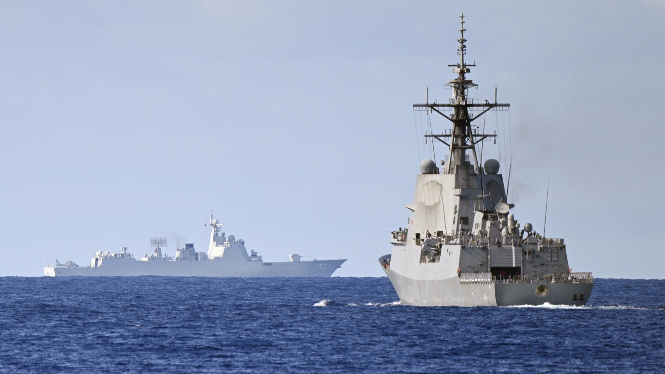 Ett kinesiskt flottfartyg i bakgrunden medan ett australiskt flottfartyg övar i Sydkinesiska havet. Foto: Ted Aljibe/AFP via Getty Images