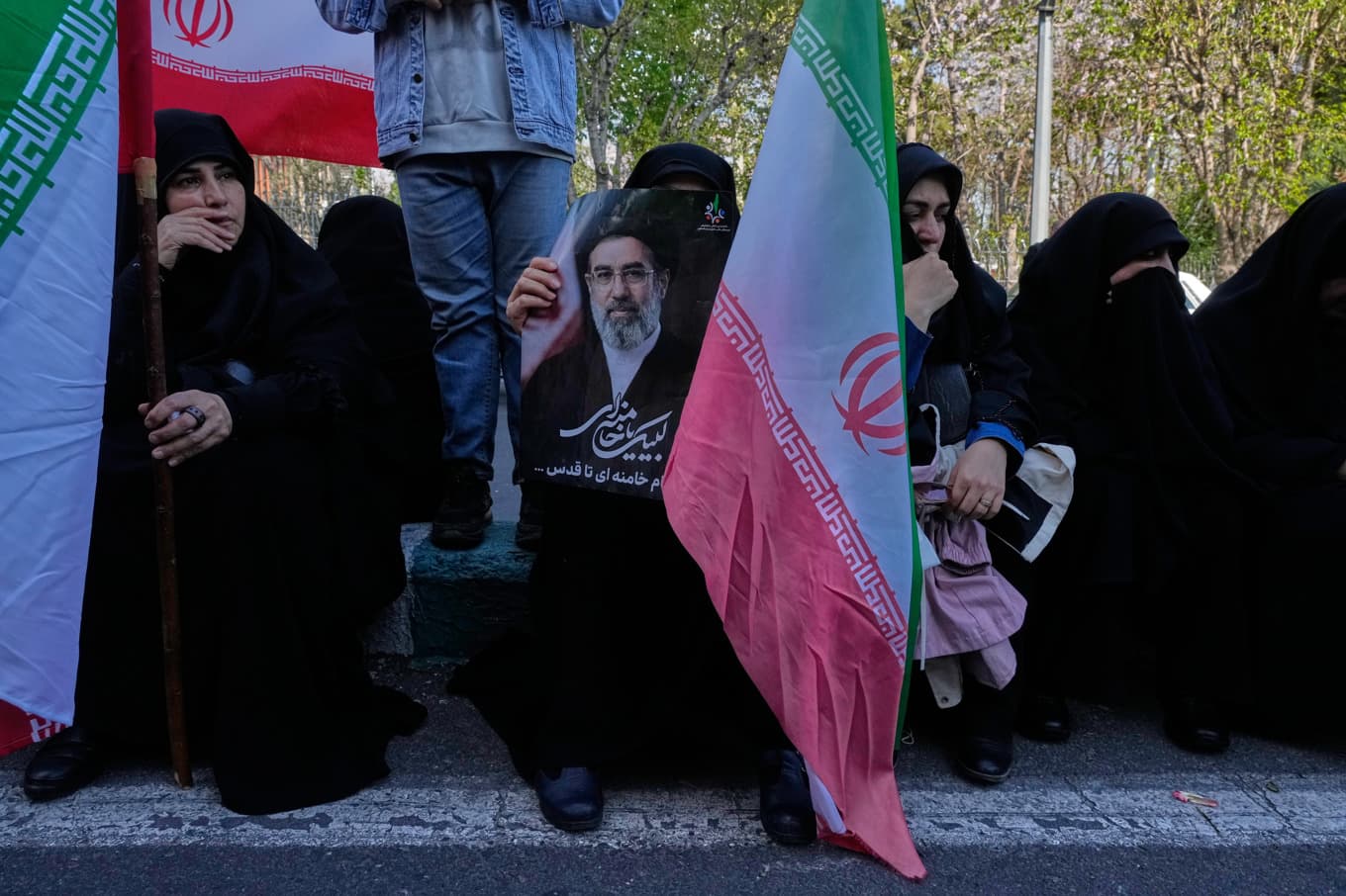 Människor håller den iranska flaggan och en bild på Irans nya ledare ayatolla Mojtaba Khamenei i Teheran. Foto: Vahid Salemi/AP/TT