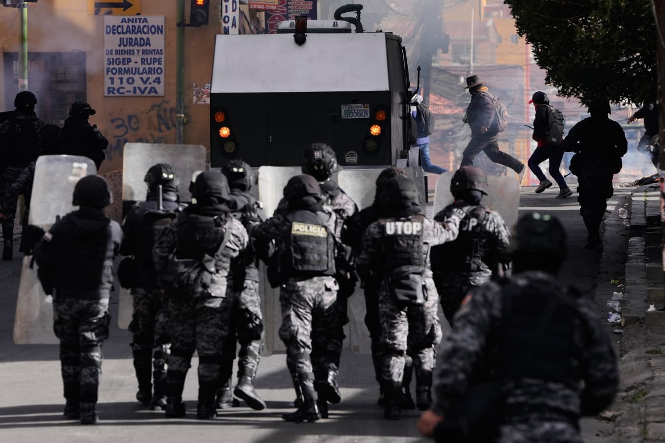 Demonstrerande springer bort från poliser i La Paz under måndagens protester. Foto: Juan Karita/AP/TT