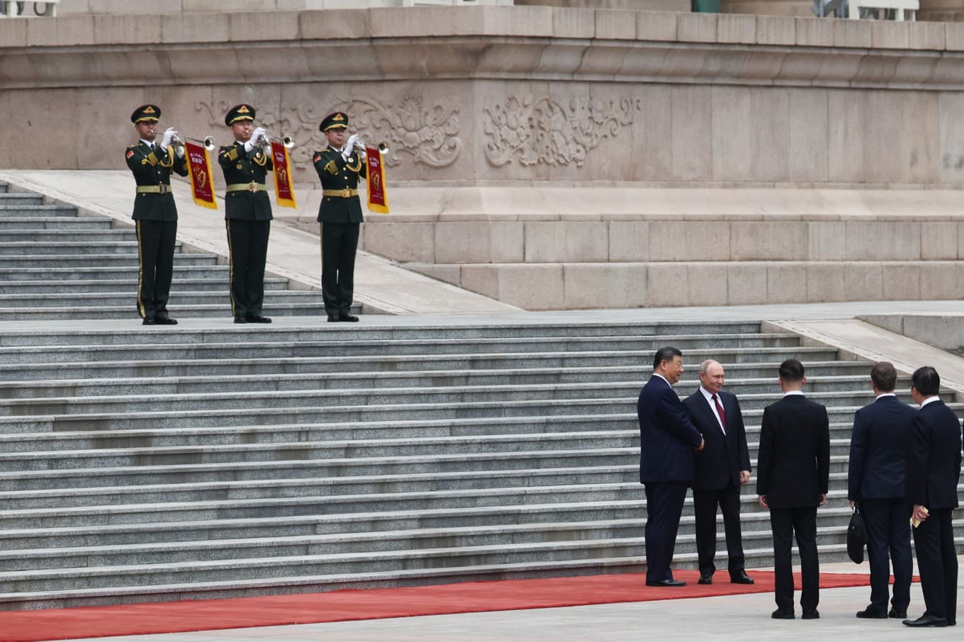 Vladimir Putin och Xi Jinping skakar hand utanför Folkets stora sal i Peking. Foto: Maxim Shemetov/AP/TT