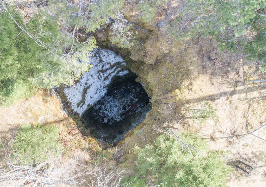 Flygfoto från gruvhålet i Långgruvan där en 20-årig kvinna hittades skadad efter att ha blivit nedknuffad av en man 2022. Nu utreds ett misstänkt mord vid platsen. Foto: Polisen/TT