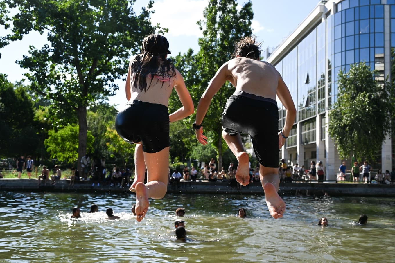 Studenter svalkar sig i Paris kanal Saint-Martin sedan ännu en värmebölja dragit in över Frankrike. Foto: Emma Da Silva/AP/TT