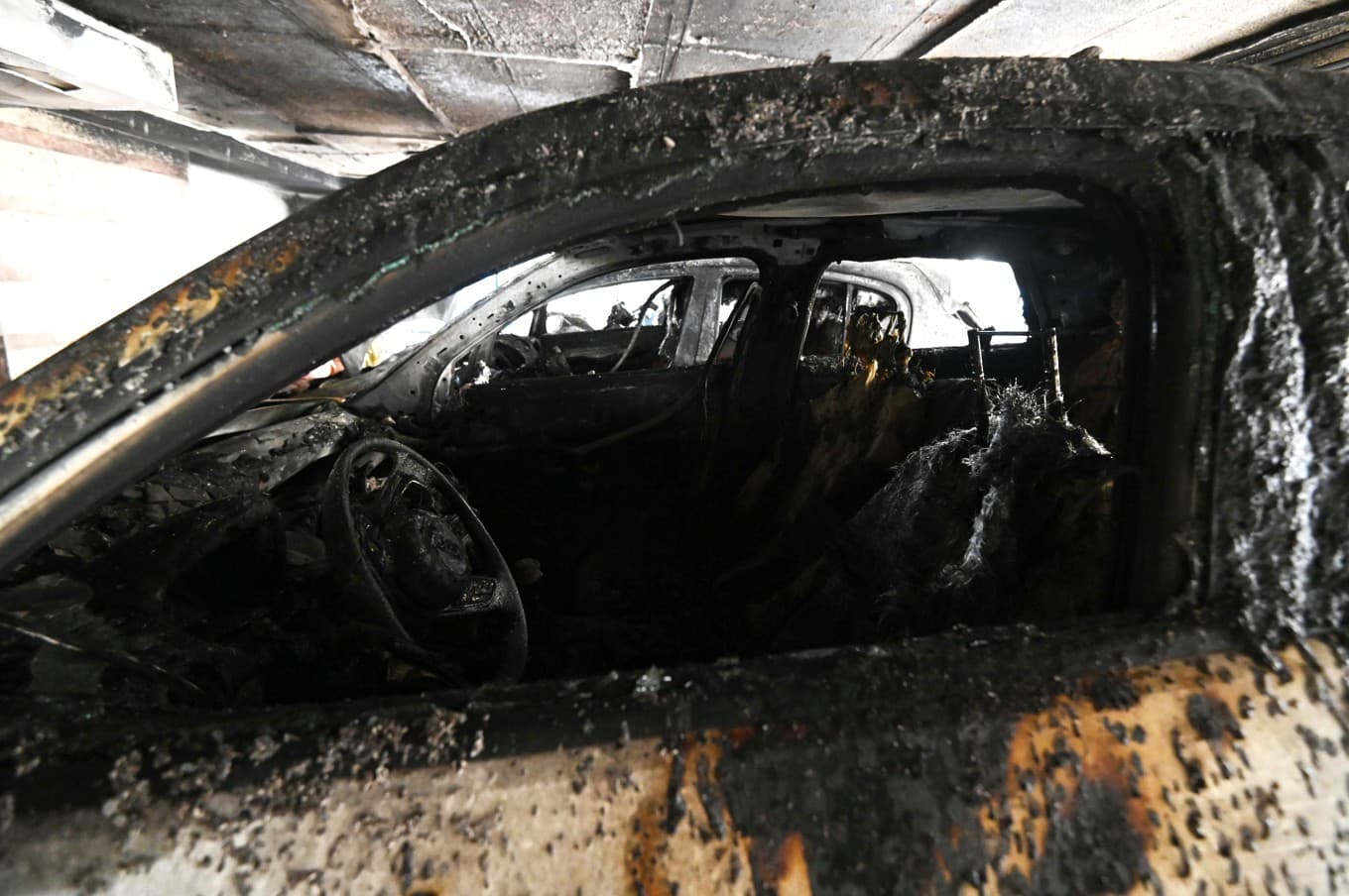 En skadad bil efter brandattackerna. Foto: Giannis Papanikos/AP/TT