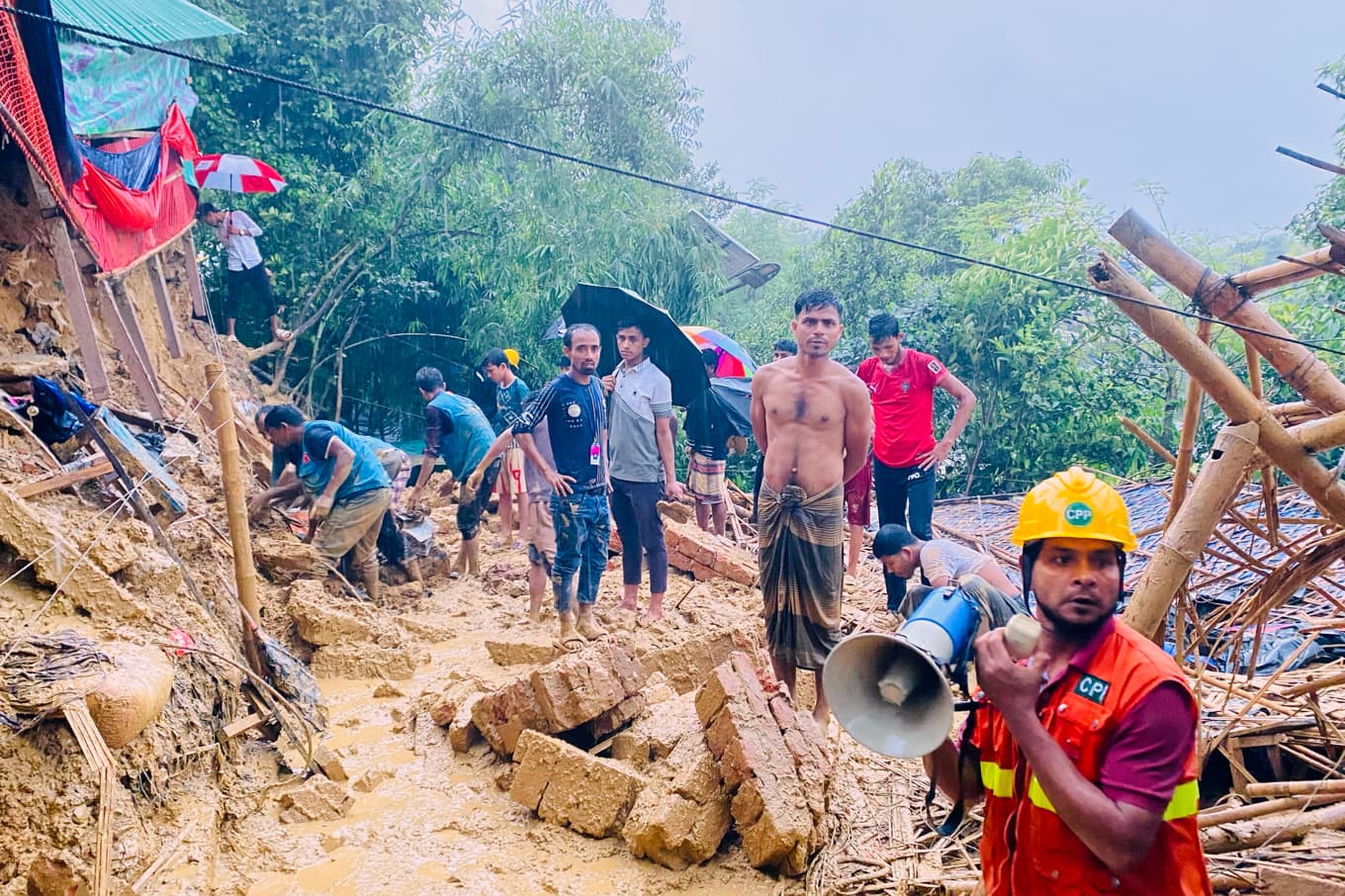 Räddningsteam arbetar vid skyfall i Bangladesh, den 8 juli. Foto: Shamimul Islam Faisal /AP/TT
