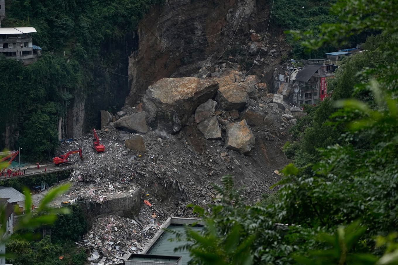 Stora mängder berg, sten och jord slungades ned från en bergssida och begravde flera bostadshus i den kinesiska staden Chongqing. Bild från 19 juli. Foto: Andy Wong/AP/TT