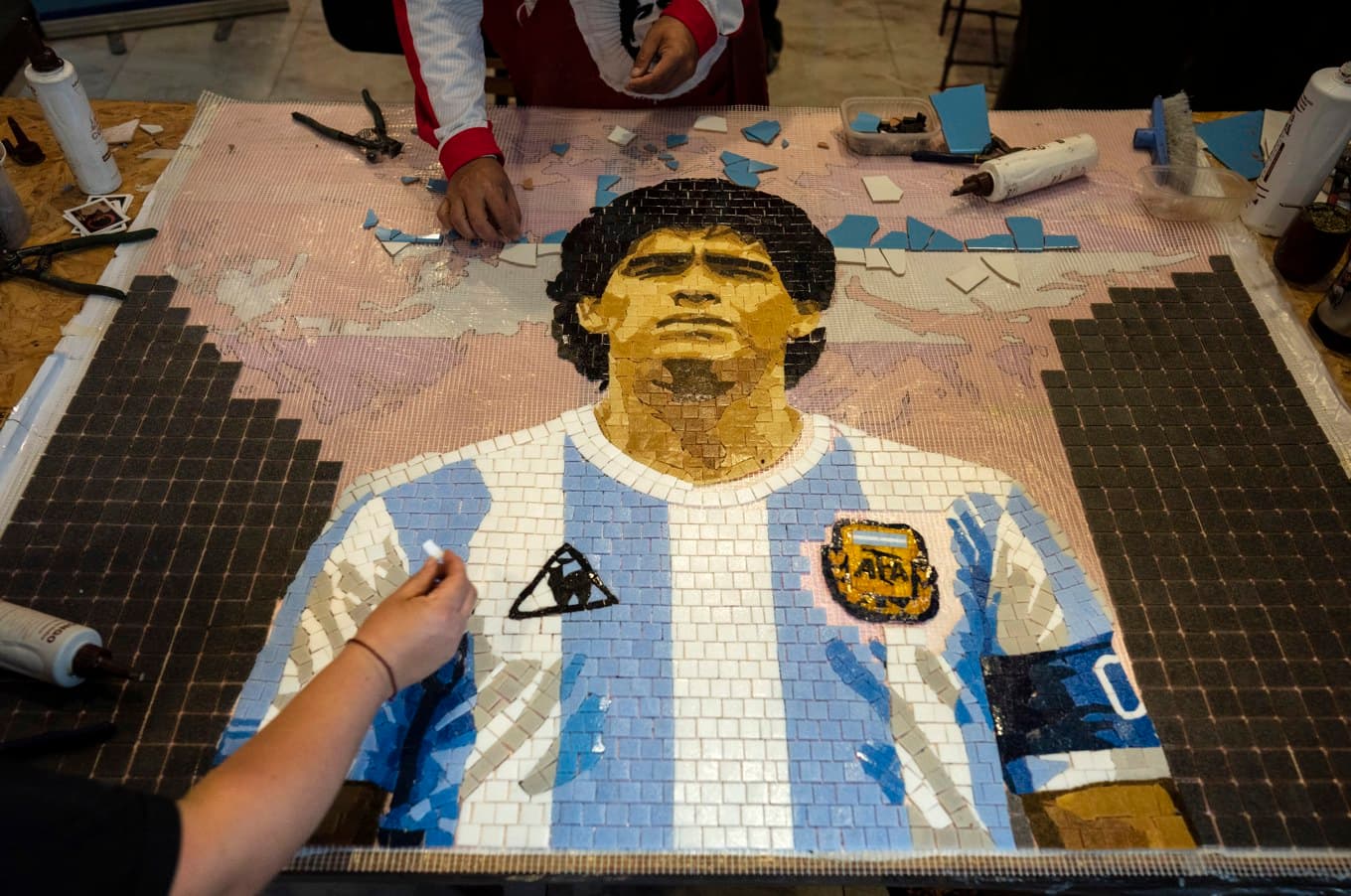 Konstnärer gör en mosaikbild av Diego Maradona för att fira hans ”Guds hand”-mål. Arkivbild. Foto: Rodrigo Abd AP/TT