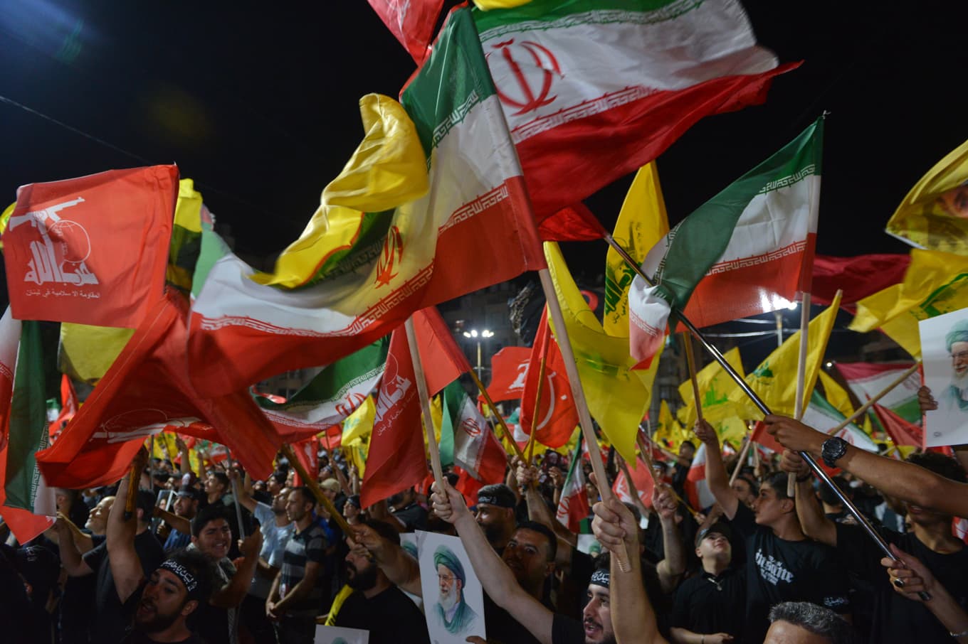 Hizbollah-anhängare viftar med Hizbollah- och iranska flaggor under en samling i Libanon i juli. Foto: Mustafa Jamalddine /AP/TT